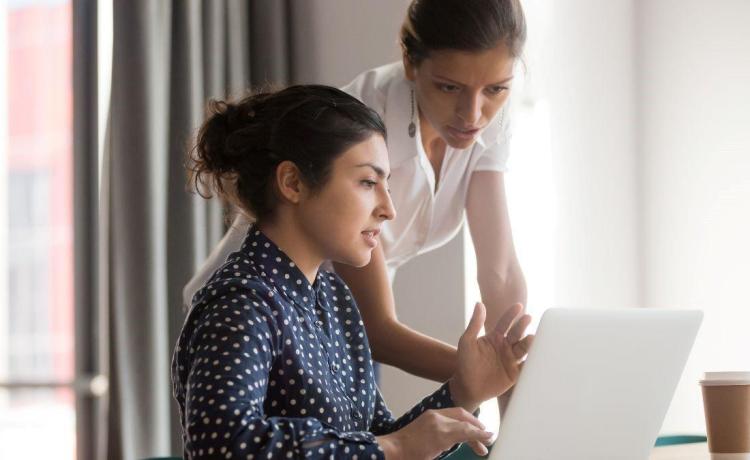 Deux femmes discutant face à un ordinateur